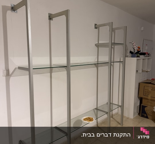 התקנת יחידת מדפי זכוכית ומתכת המחוברת לקיר